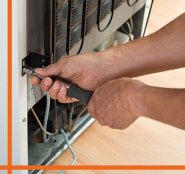 close-up-of-a-technicians-hands-holding-a-screwdriver-while-checking-a-refrigerators-back-fort-collins-co