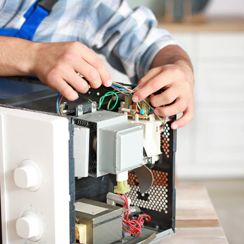technician-close-up-repairing-microwave-at-kitchen-fort-collins-co