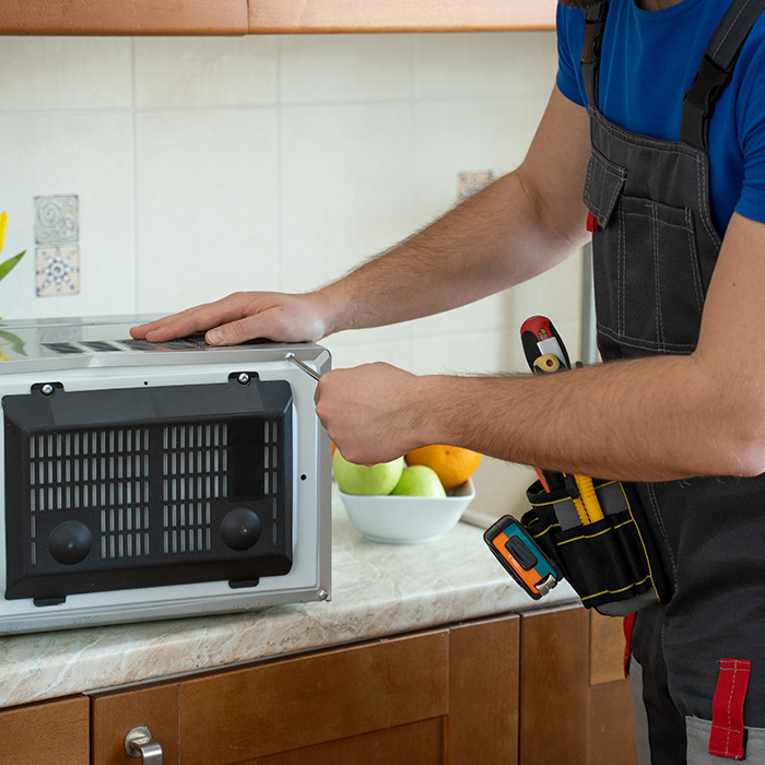 technician-close-up-repairing-microwave-on-top-of-sink-fort-collins-co