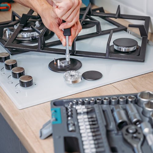 technician-hands-with-screwdriver-repairing-stove-close-up-fort-collins-co